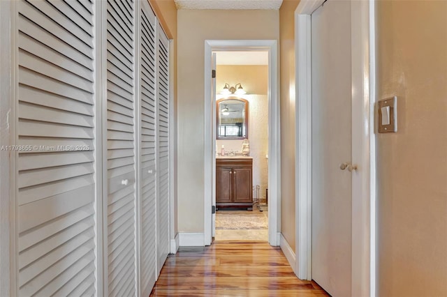 9829 Riverside Dr Unit 42-6, Coral Springs, FL 33071 - hall featuring a sink, light wood-style flooring, and baseboards
