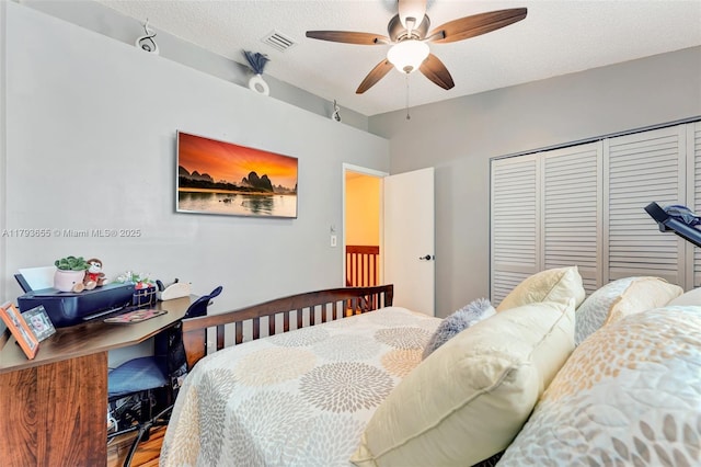 bedroom with visible vents, a closet, wood finished floors, a textured ceiling, and a ceiling fan