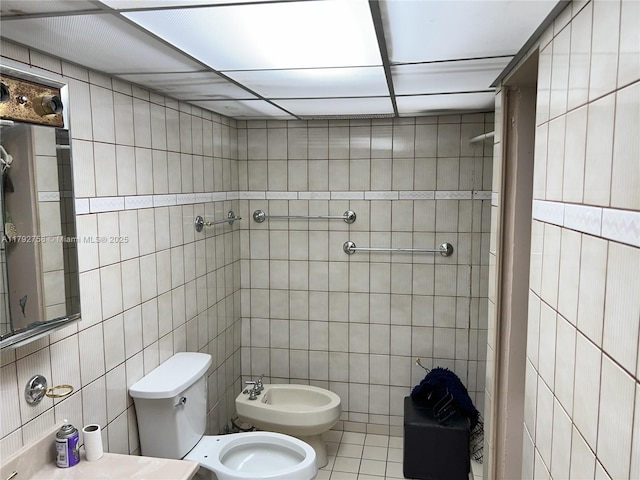 5005 Collins Ave Unit 214, Miami Beach, FL 33140 - bathroom featuring tile walls, tile patterned flooring, toilet, and a bidet