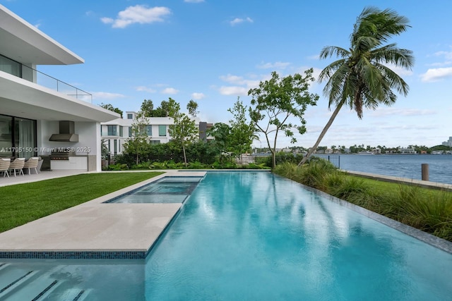 310 W Dilido Dr, Miami Beach, FL 33139 - view of pool with exterior kitchen, a patio area, a yard, a water view, and a pool with connected hot tub