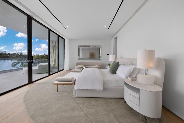 310 W Dilido Dr, Miami Beach, FL 33139 - bedroom with access to exterior, expansive windows, wood finished floors, and a water view