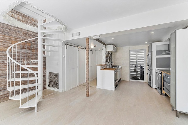 517 NE 38th St Unit 9, Miami, FL 33137 - below grade area with freestanding refrigerator, light wood-type flooring, stairs, and a barn door