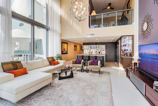 living area featuring visible vents, a towering ceiling, and a chandelier