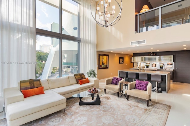 living room with visible vents, a towering ceiling, and a chandelier