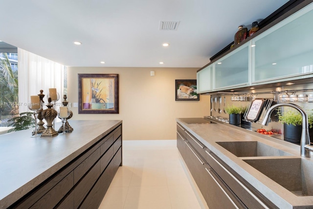 kitchen featuring recessed lighting, visible vents, glass insert cabinets, and a sink