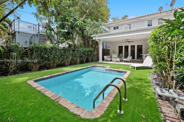 pool featuring a lawn, a ceiling fan, a patio area, and fence