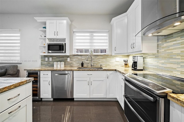 kitchen featuring wall chimney range hood, decorative backsplash, a sink, wine cooler, and stainless steel appliances
