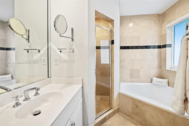 bathroom featuring vanity, a relaxing tiled tub, and a stall shower