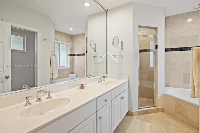 bathroom with double vanity, a shower stall, and a sink