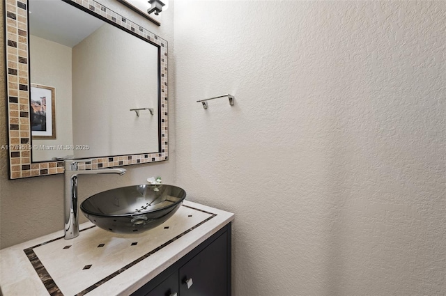 bathroom with vanity and a textured wall