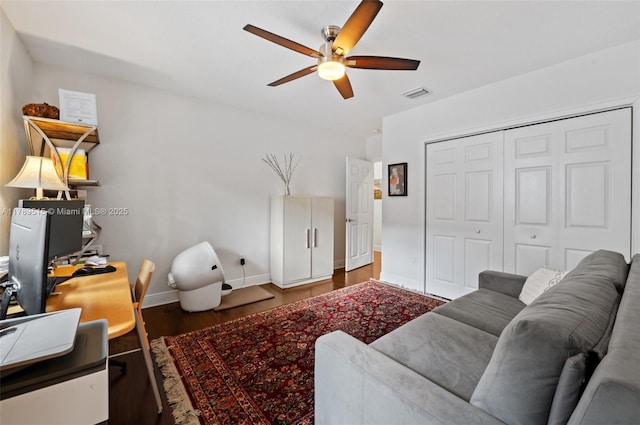 living room with baseboards, a ceiling fan, wood finished floors, and visible vents