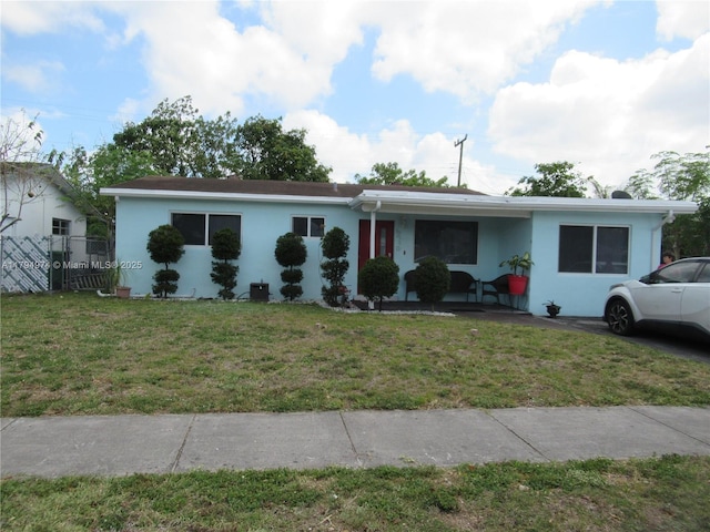 view of front facade with a front lawn, stucco siding, and covered porch
