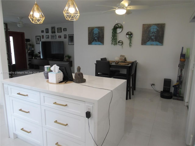 kitchen with white cabinets, ceiling fan, hanging light fixtures, light countertops, and ornamental molding