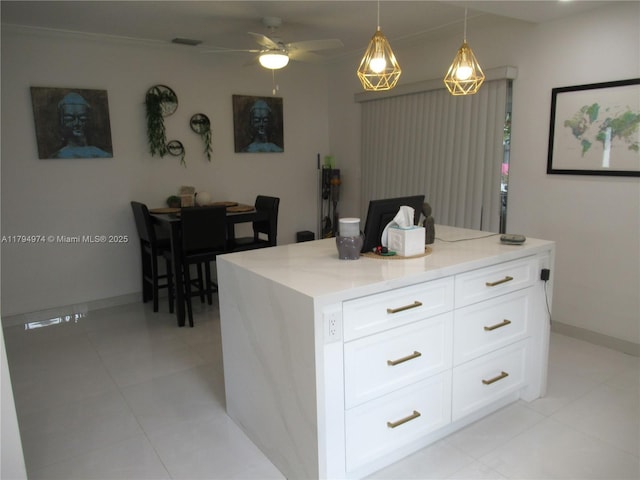 kitchen featuring light stone countertops, baseboards, ceiling fan, white cabinets, and decorative light fixtures