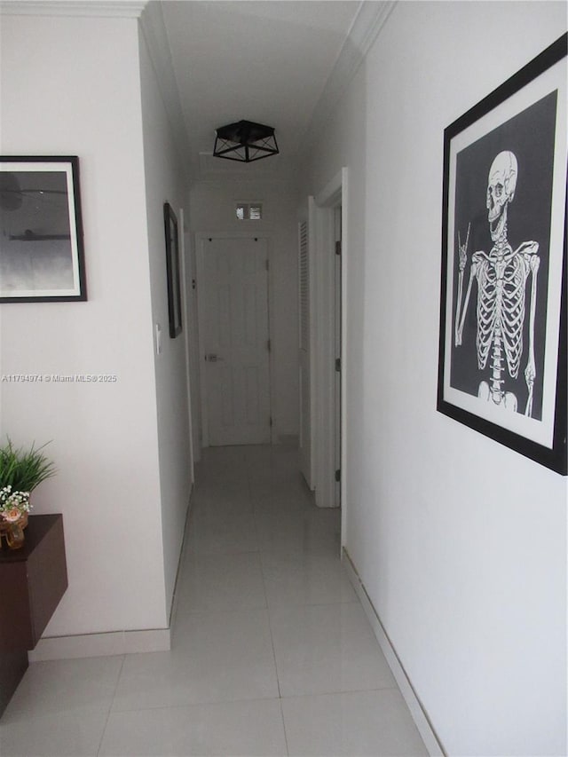 hall featuring baseboards and light tile patterned floors
