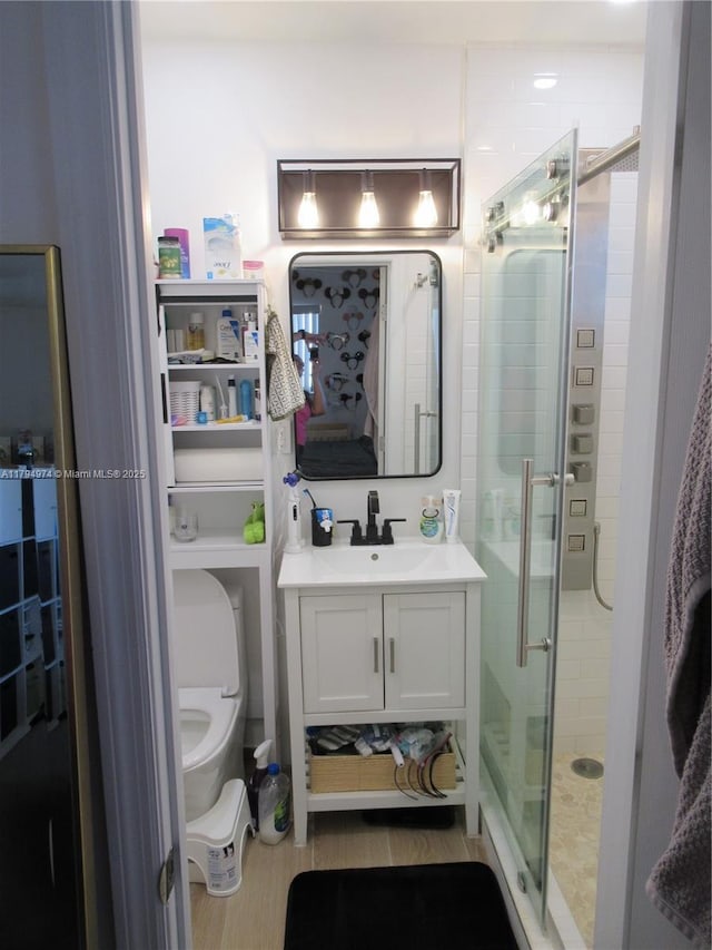 bathroom featuring vanity, a stall shower, and toilet