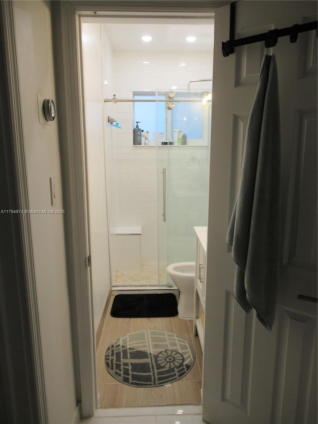 full bathroom featuring a shower stall, wood finished floors, vanity, toilet, and recessed lighting