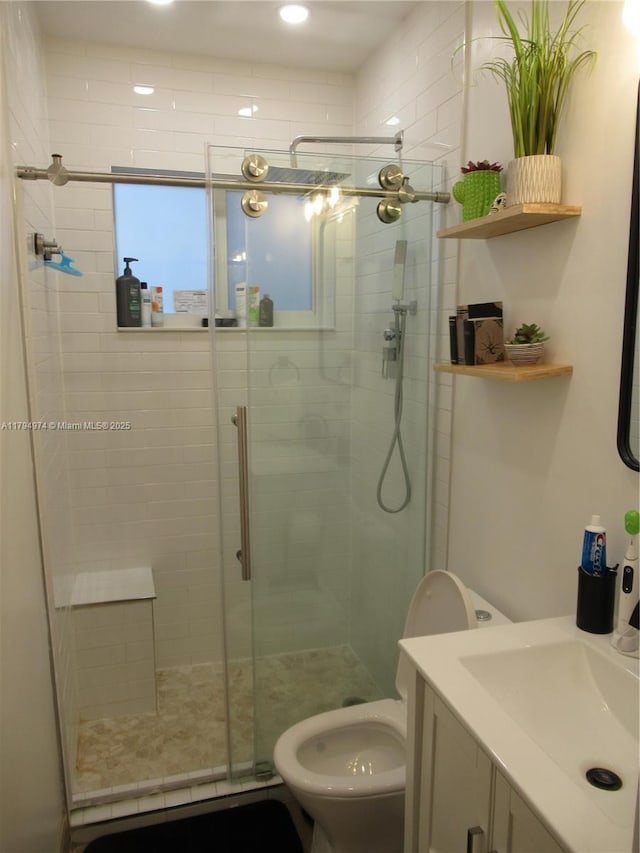 bathroom with vanity, a stall shower, and toilet