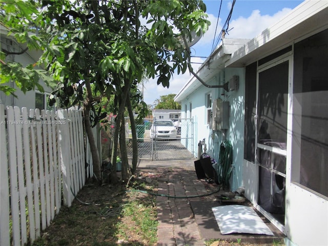 view of side of property featuring fence, a gate, and stucco siding