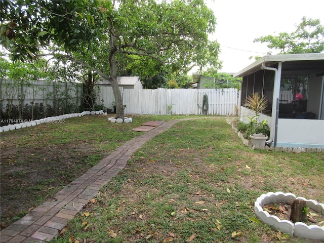 view of yard with a sunroom and a fenced backyard