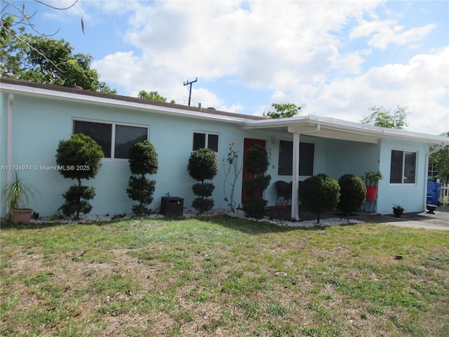 ranch-style house featuring stucco siding and a front yard