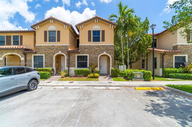 9371 W 33rd Ave, Hialeah, FL 33018 - view of front of property with stone siding, stucco siding, uncovered parking, and a tile roof