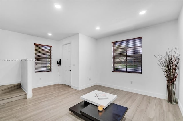 unfurnished living room with baseboards, light wood finished floors, and recessed lighting
