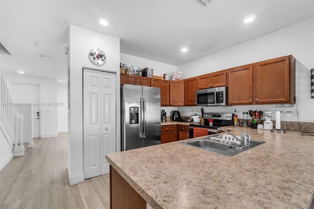kitchen featuring a sink, a peninsula, stainless steel appliances, brown cabinets, and light countertops