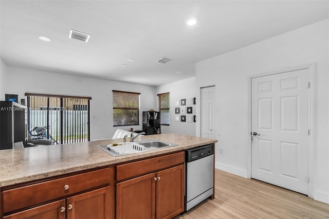 kitchen featuring dishwasher, light countertops, visible vents, and a sink