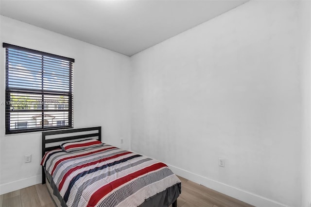 bedroom featuring wood finished floors and baseboards