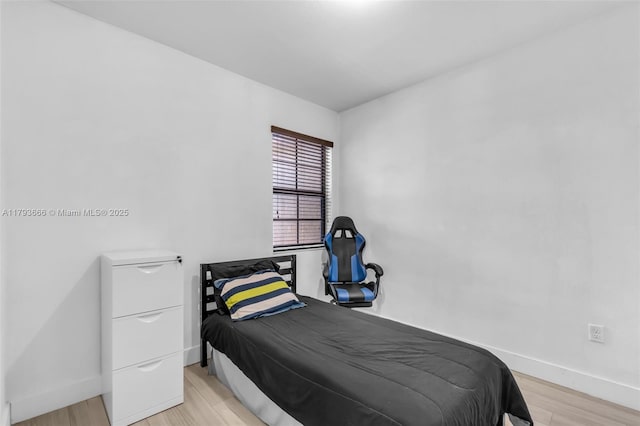 bedroom with light wood finished floors and baseboards