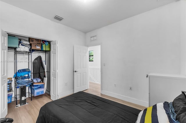 bedroom featuring light wood finished floors, baseboards, and visible vents
