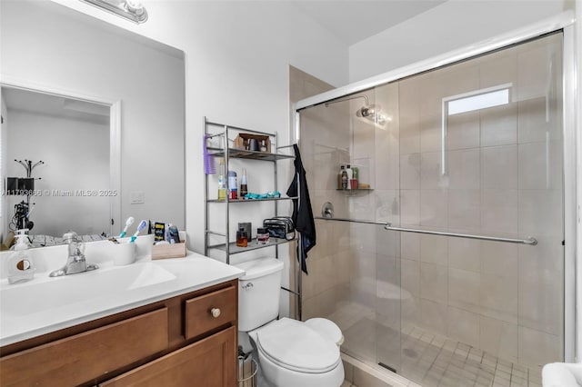 bathroom with vanity, toilet, and a shower stall
