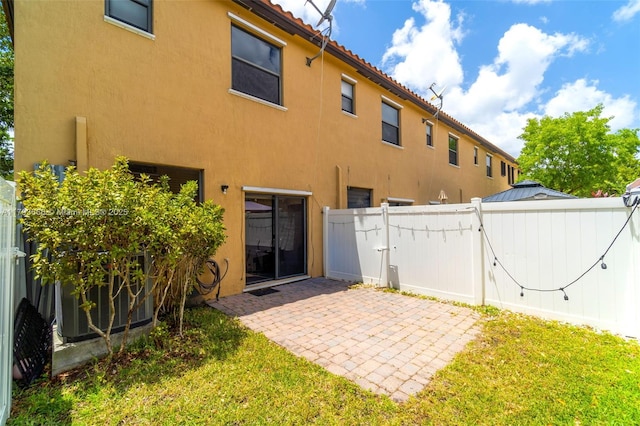 back of property featuring a gate, stucco siding, fence, a yard, and a patio area