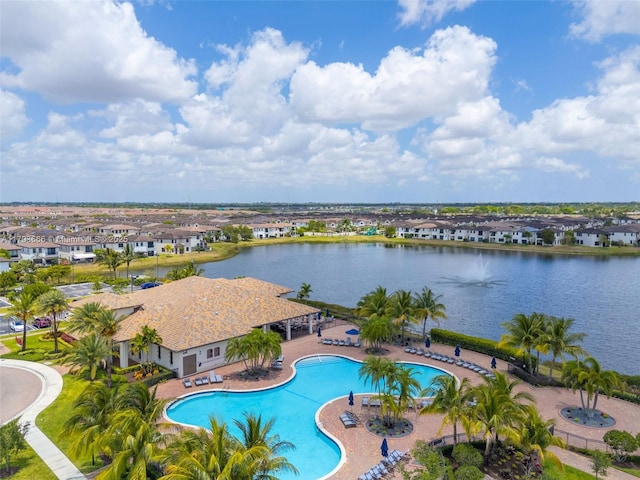 community pool with a water view, a patio, and a residential view