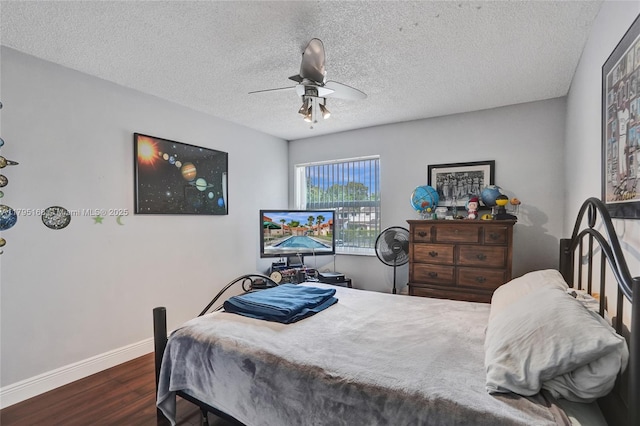 bedroom featuring baseboards, a textured ceiling, ceiling fan, and dark wood-style floors
