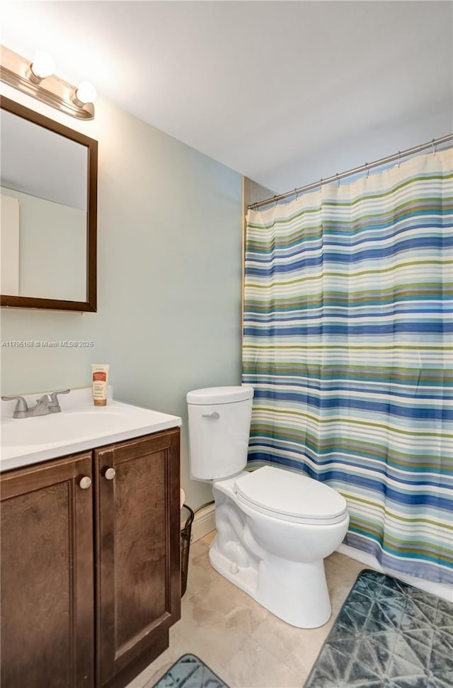 bathroom featuring vanity, curtained shower, and toilet