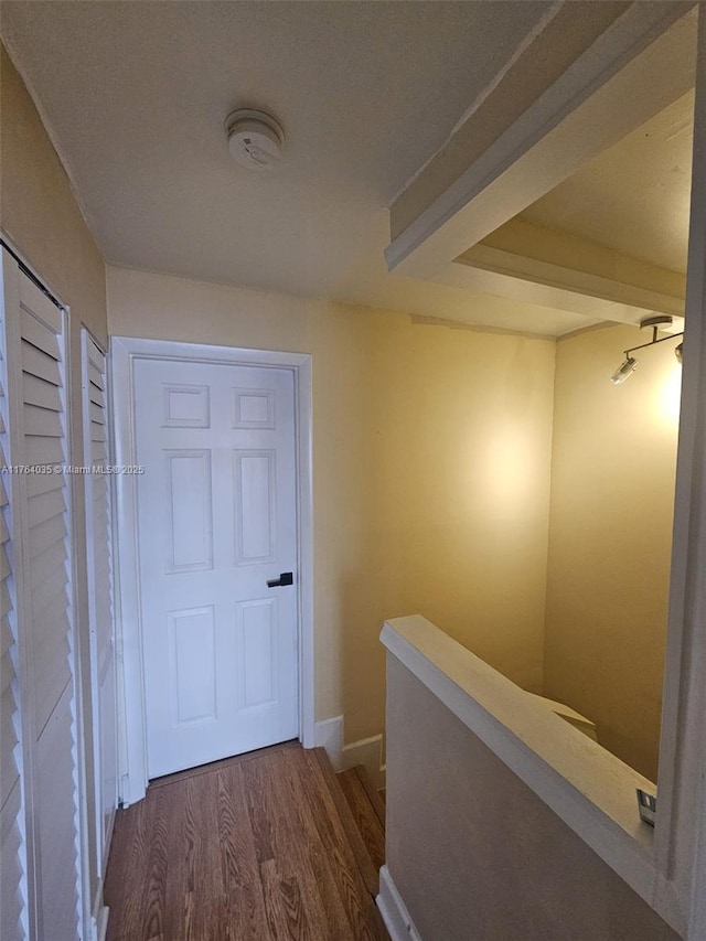 hall featuring dark wood-style flooring and an upstairs landing