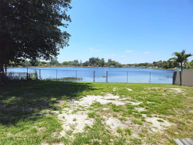 view of yard with fence and a water view