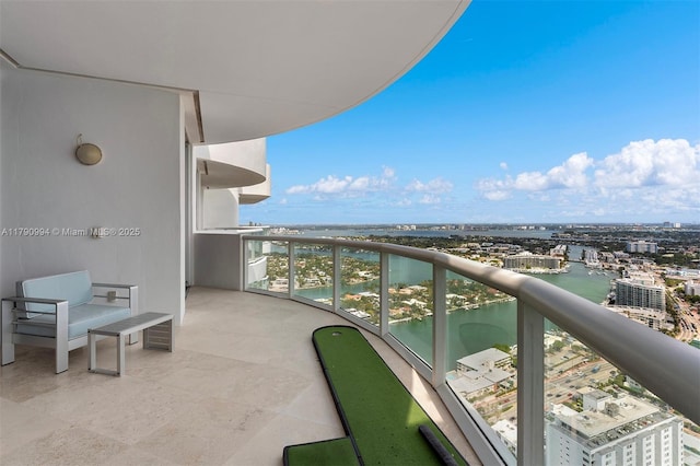 balcony featuring a water view and a city view