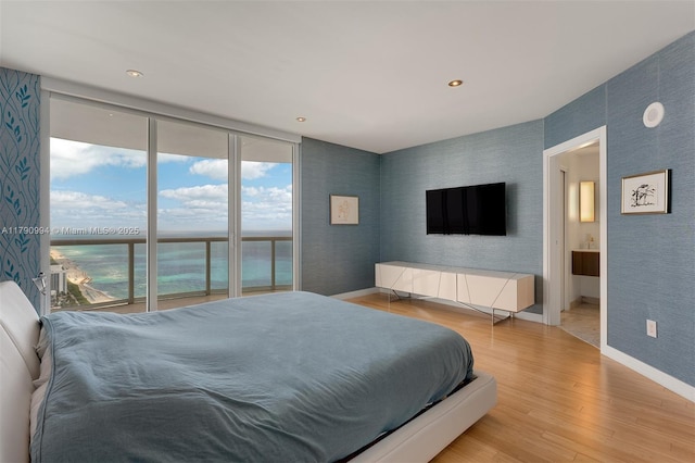 bedroom featuring baseboards, access to exterior, wood finished floors, and wallpapered walls