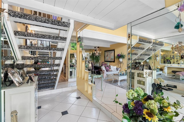 interior space featuring light tile patterned floors, an inviting chandelier, and stairs