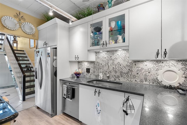 kitchen with white cabinets, appliances with stainless steel finishes, decorative backsplash, and a sink