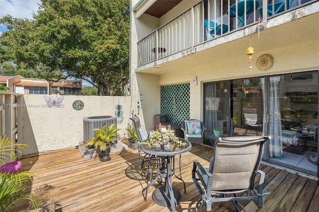 wooden terrace featuring central air condition unit and fence
