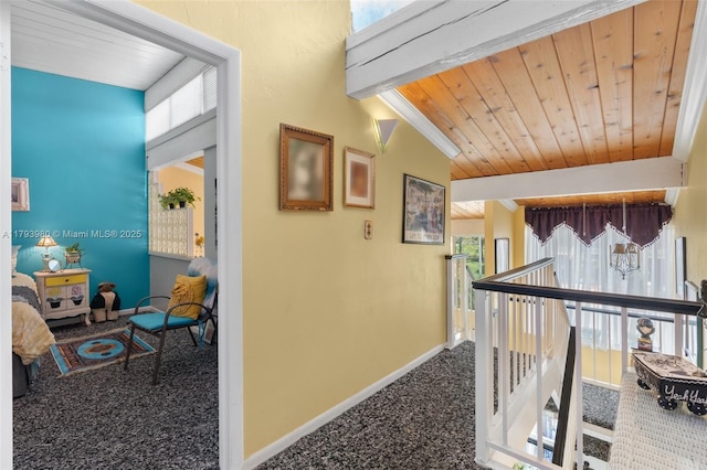 hallway featuring baseboards, plenty of natural light, carpet, and an upstairs landing
