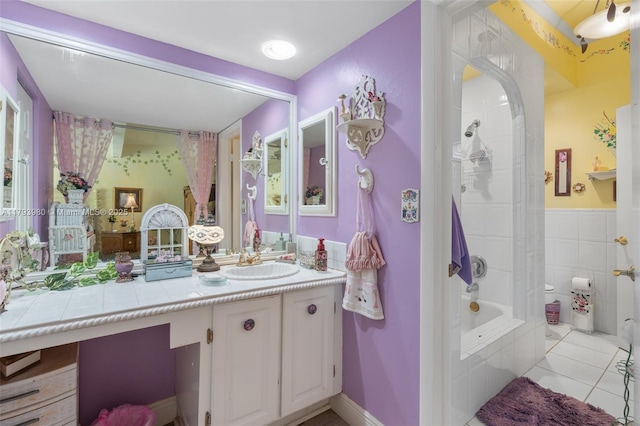 bathroom with vanity, tile patterned flooring, and tiled shower / bath