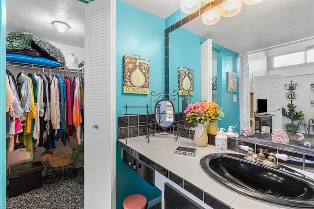 bathroom featuring vanity and a spacious closet