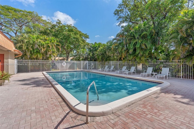 community pool with fence and a patio area