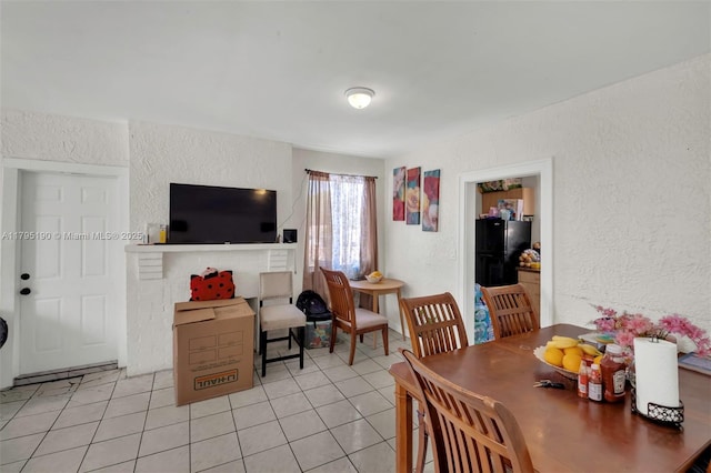 dining room with light tile patterned floors and a textured wall