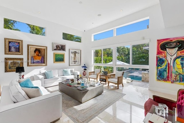 living area with recessed lighting, a towering ceiling, and a wealth of natural light